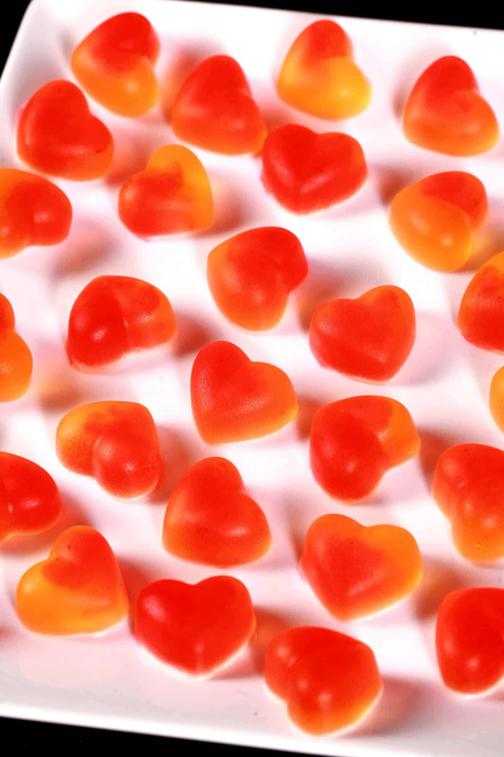 A plate two toned, heart shaped, high protein sugar free sour peach gummies.