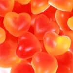 A plate two toned, heart shaped, high protein keto sour peach gummies.