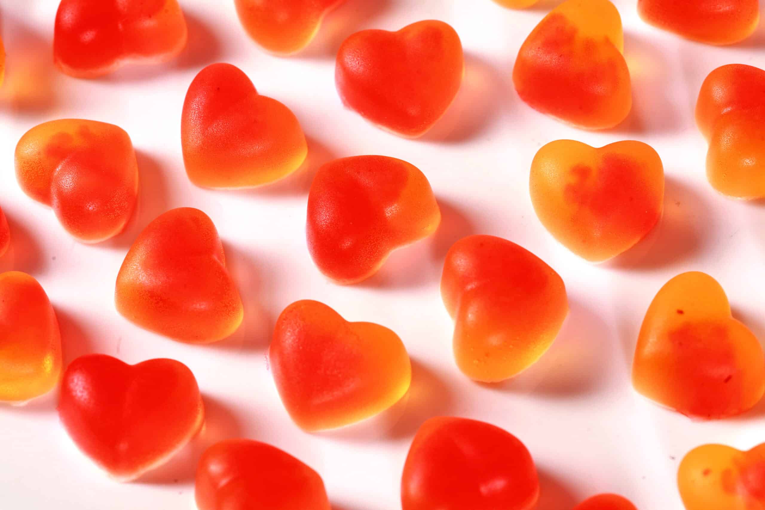 A plate two toned, heart shaped, high protein sugar free sour peach gummies.
