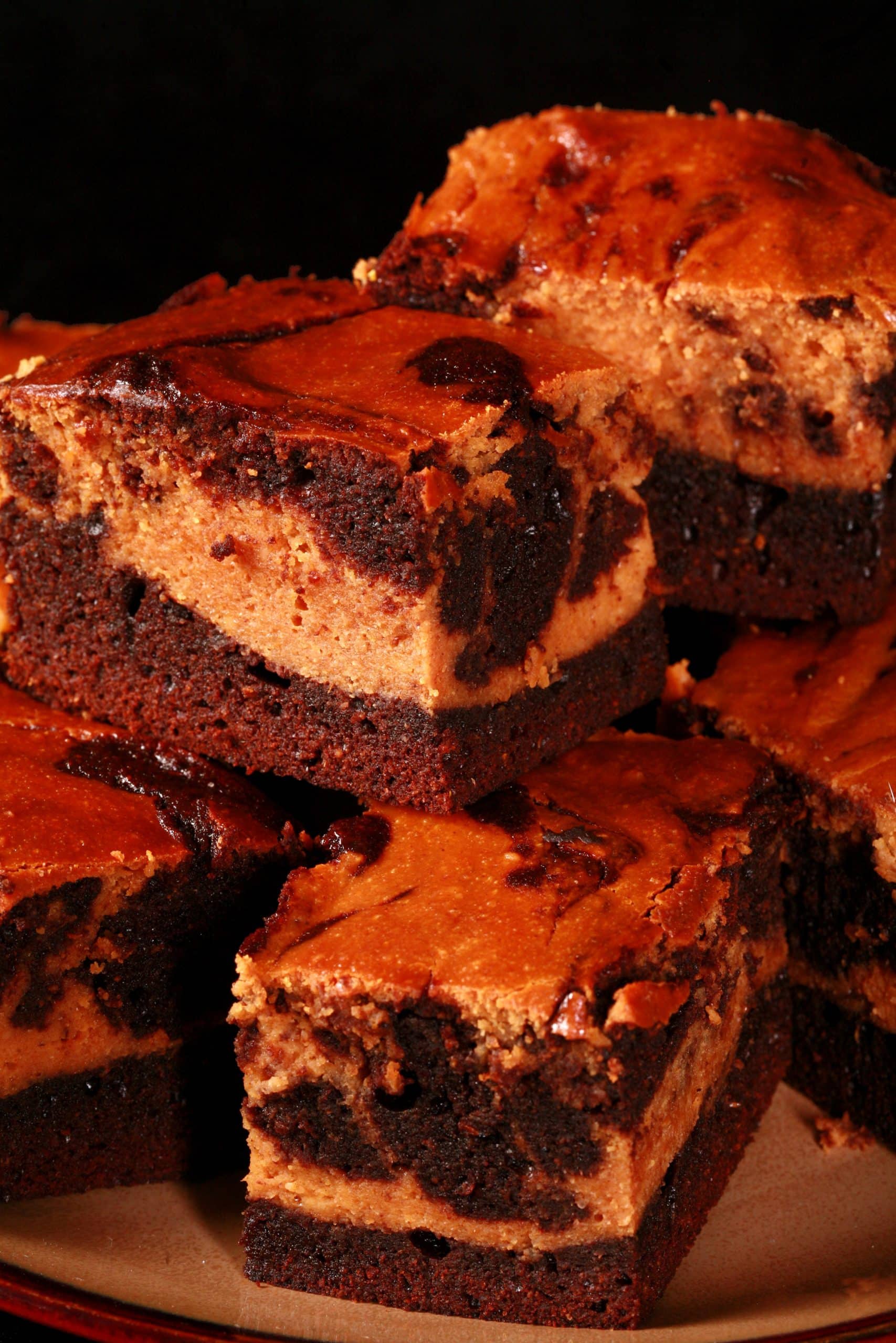 A plate of marbled keto pumpkin cheesecake brownies.