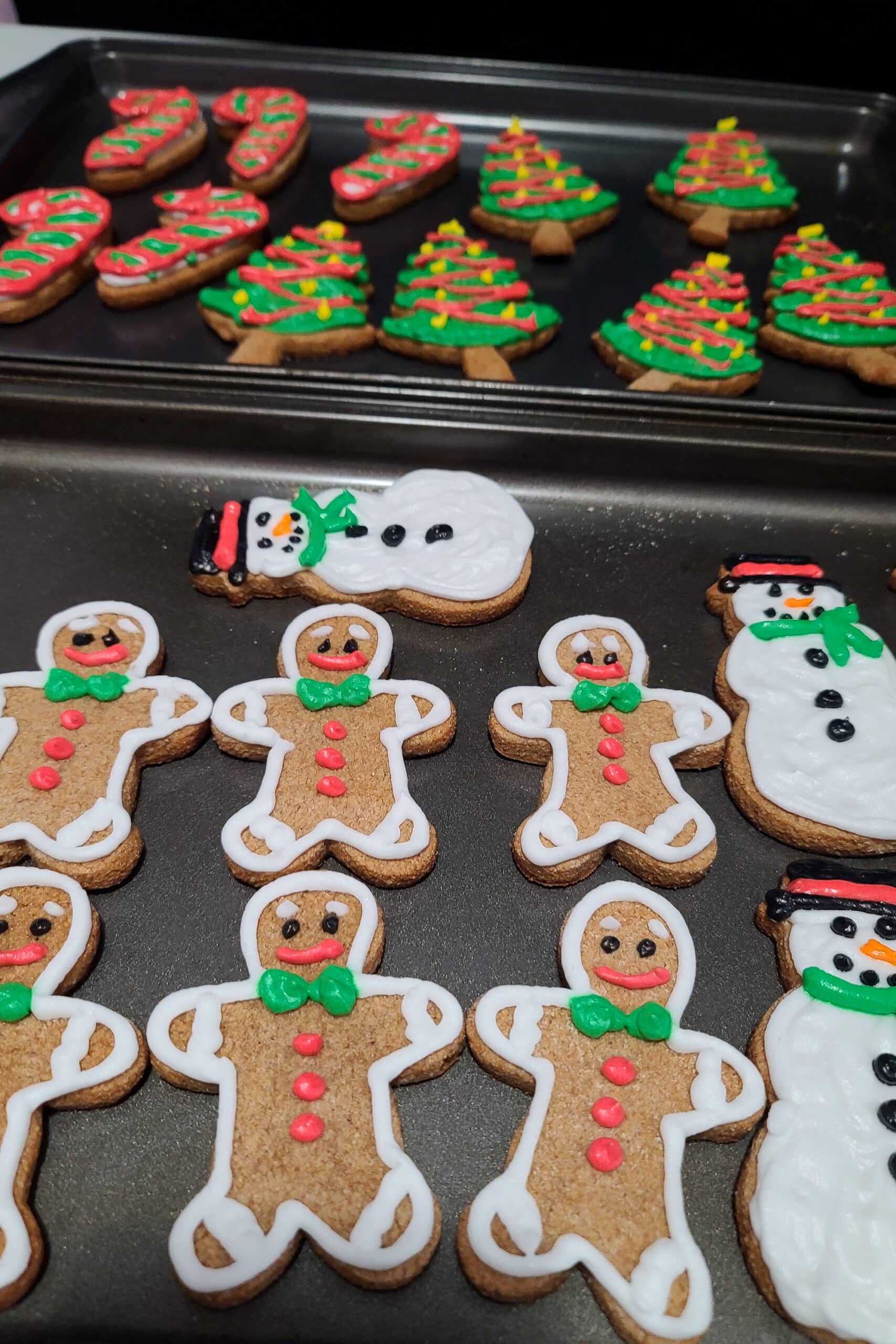 2 pans of decorated keto gingerbread cookies.