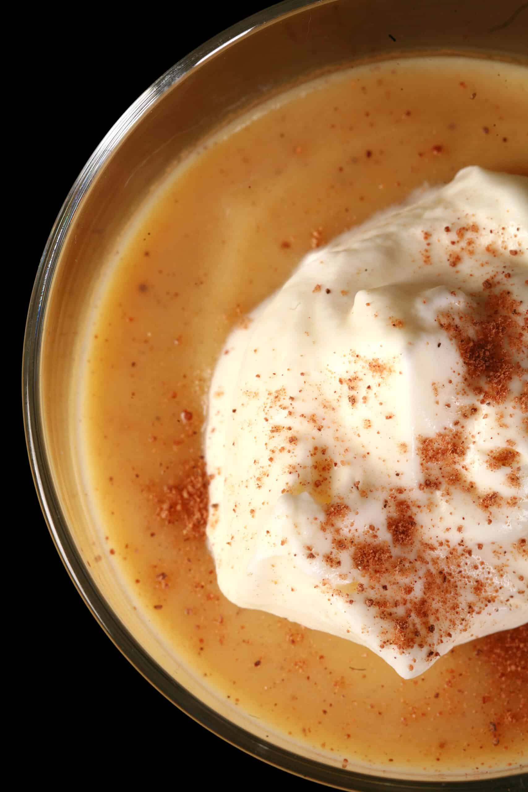 A glass of low carb eggnog pudding garnished with whipped cream and nutmeg,