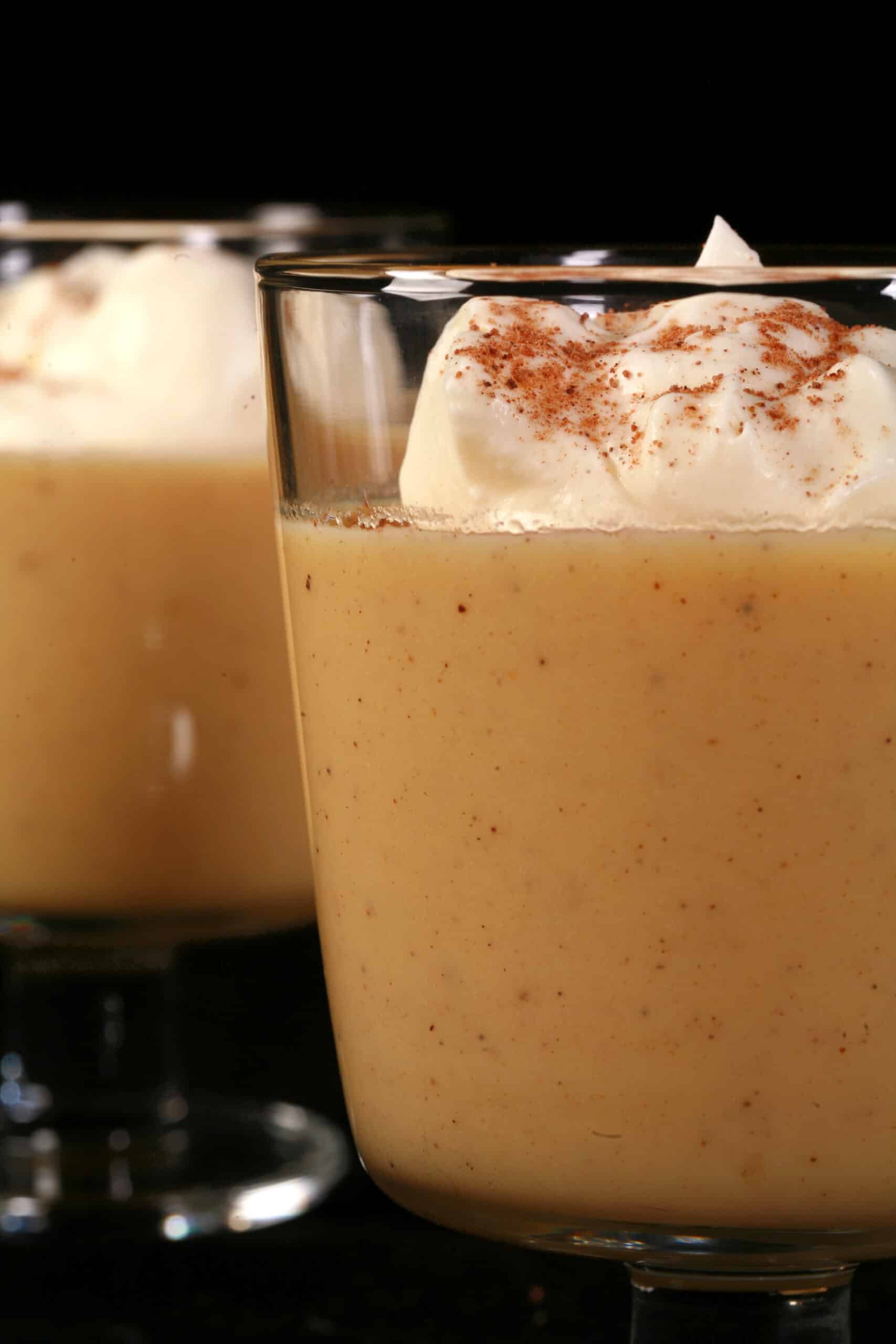 2 glasses of low carb eggnog pudding garnished with whipped cream and nutmeg,