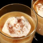 2 glasses of of keto eggnog pudding garnished with whipped cream and nutmeg,