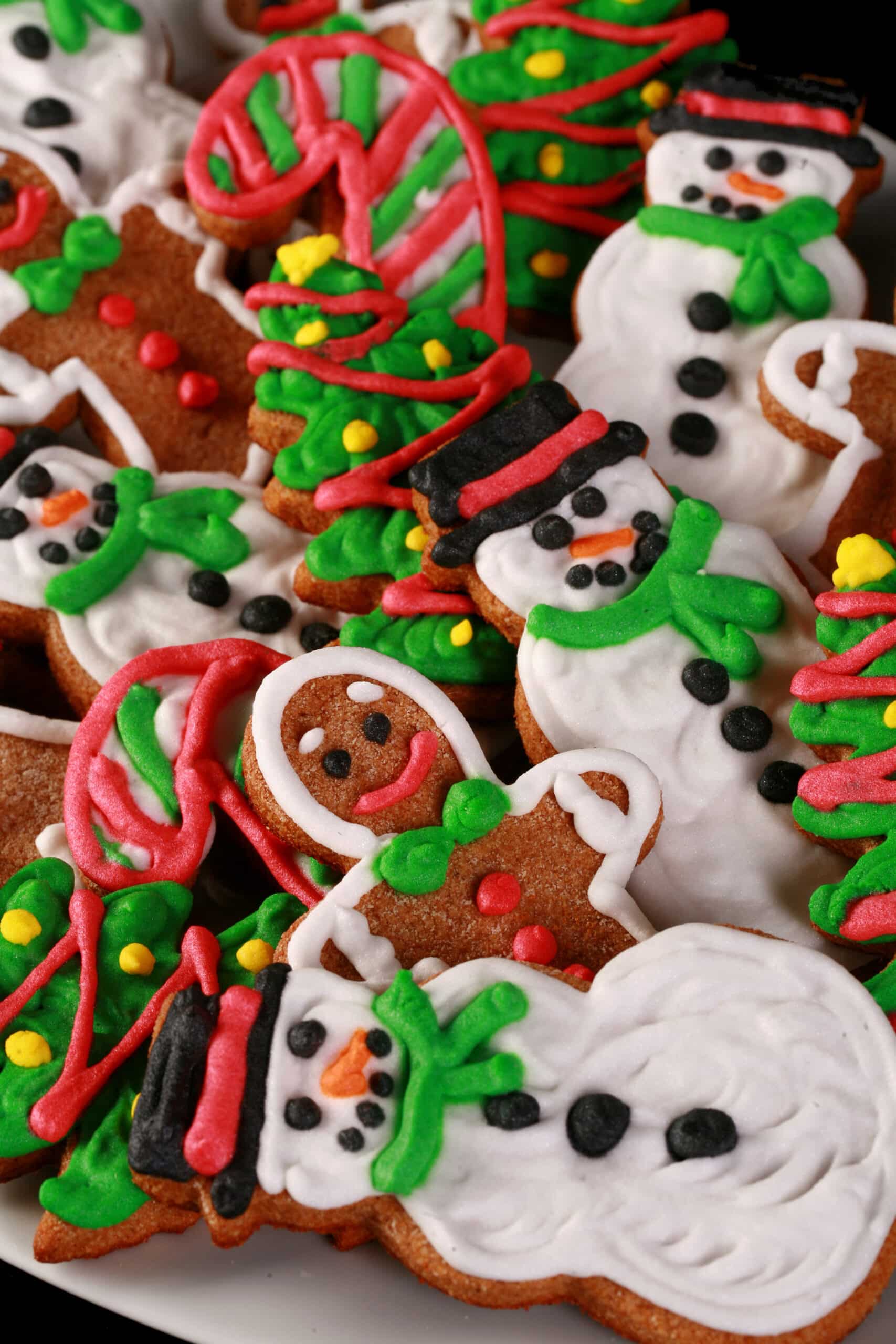 A plate of brightly decorated keto gingerbread cookies in festive shapes.