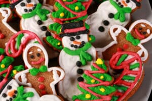 A plate of brightly decorated low carb gingerbread cookies in festive shapes.