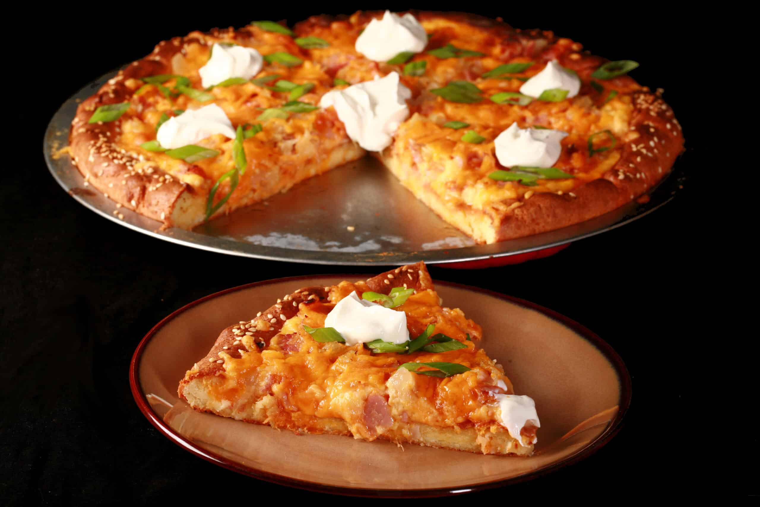 A low carb pierogi pizza topped with sour cream and sliced green onions.