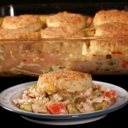 Close up view of a serving of keto chicken pot pie casserole, with a serving in front of it.