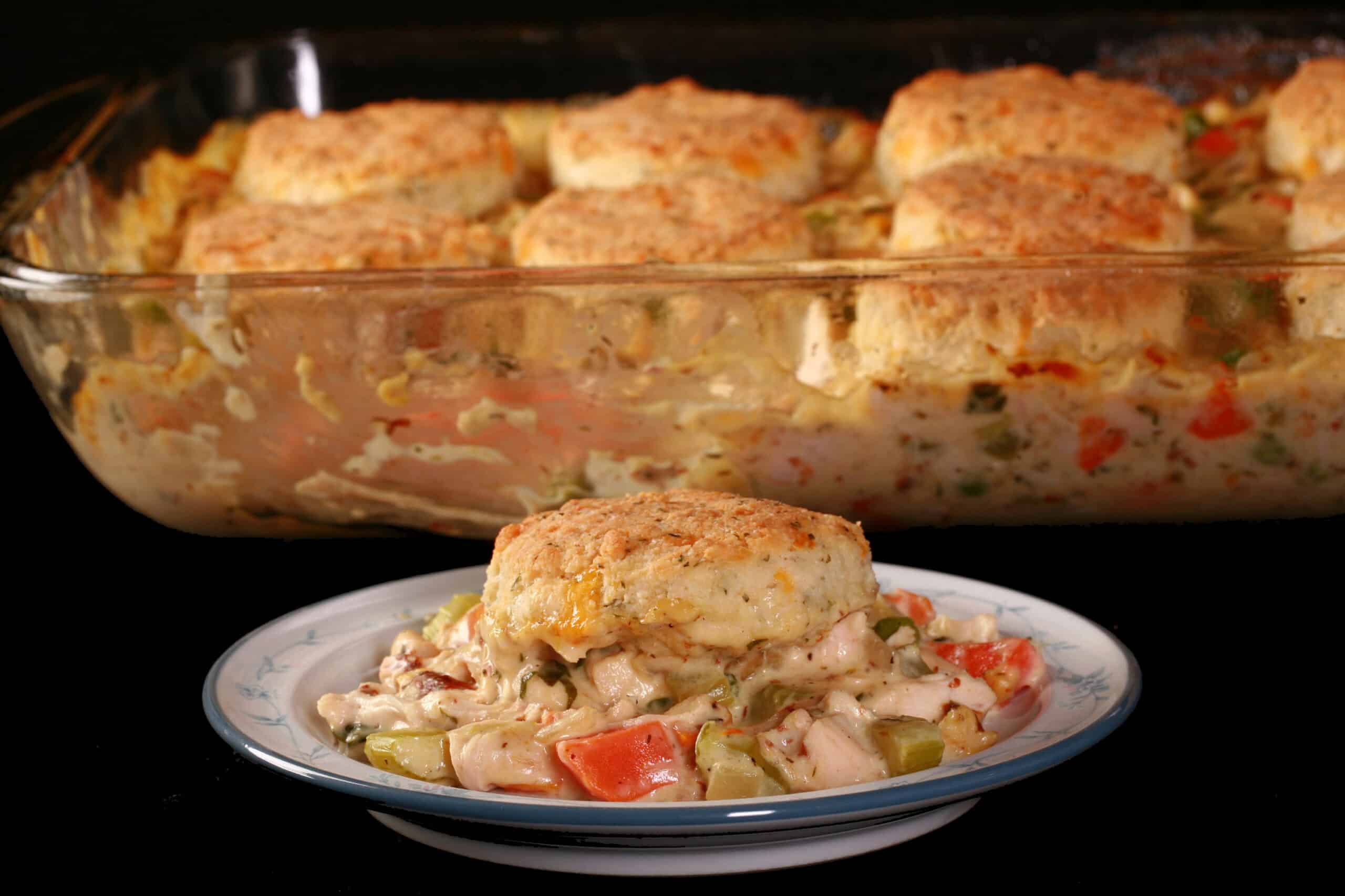 Close up view of a serving of keto chicken pot pie casserole, with a serving in front of it.