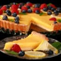A sugar free lemon tart, garnished with lemon slices, berries, and mint leaves.