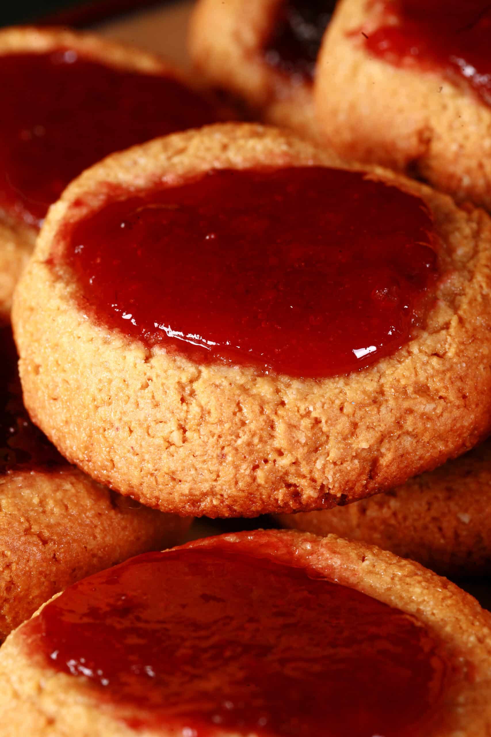 A plate of low carb peanut butter thumbprint cookies, topped with sugar free blueberry and sugar free strawberry jam.