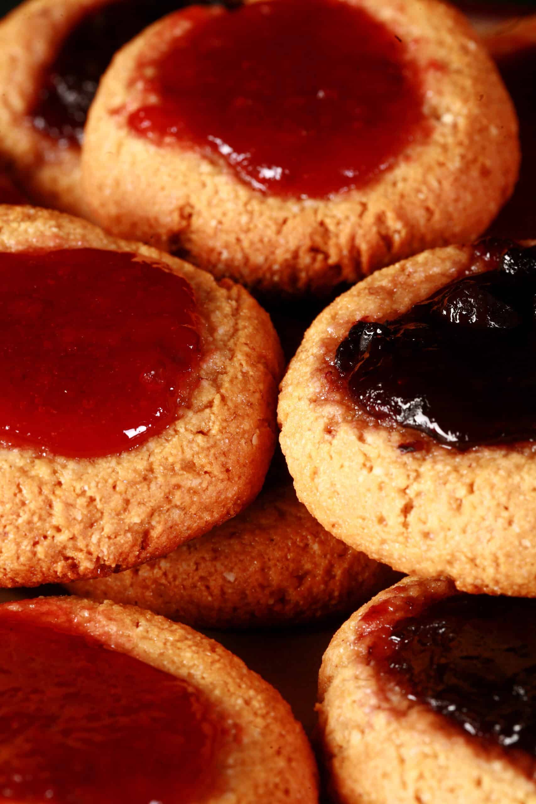 A plate of keto peanut butter and jelly cookies, topped with sugar free blueberry and sugar free strawberry jam.