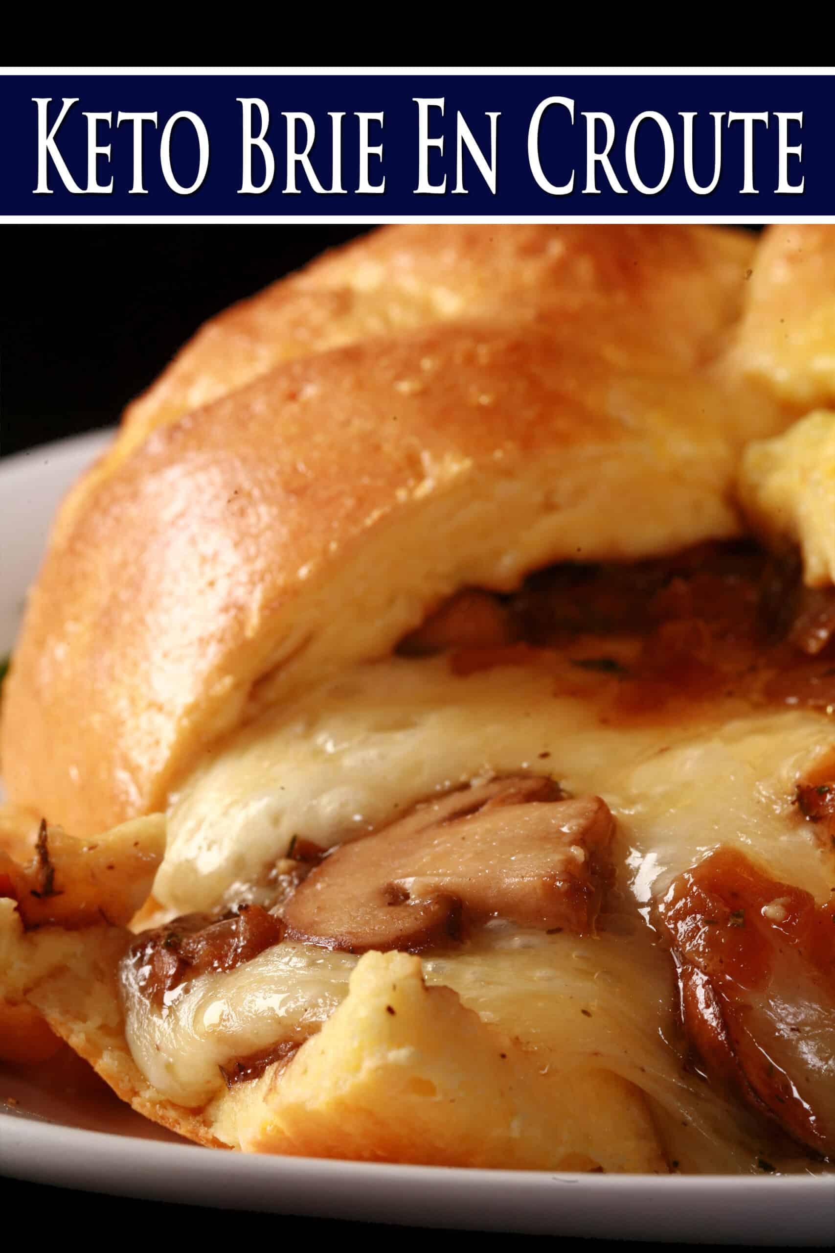 A fathead wrapped low carb brie en croute, cut open to show melted cheese and sauteed mushrooms pouring out.  Overlaid text says keto brie en croute.