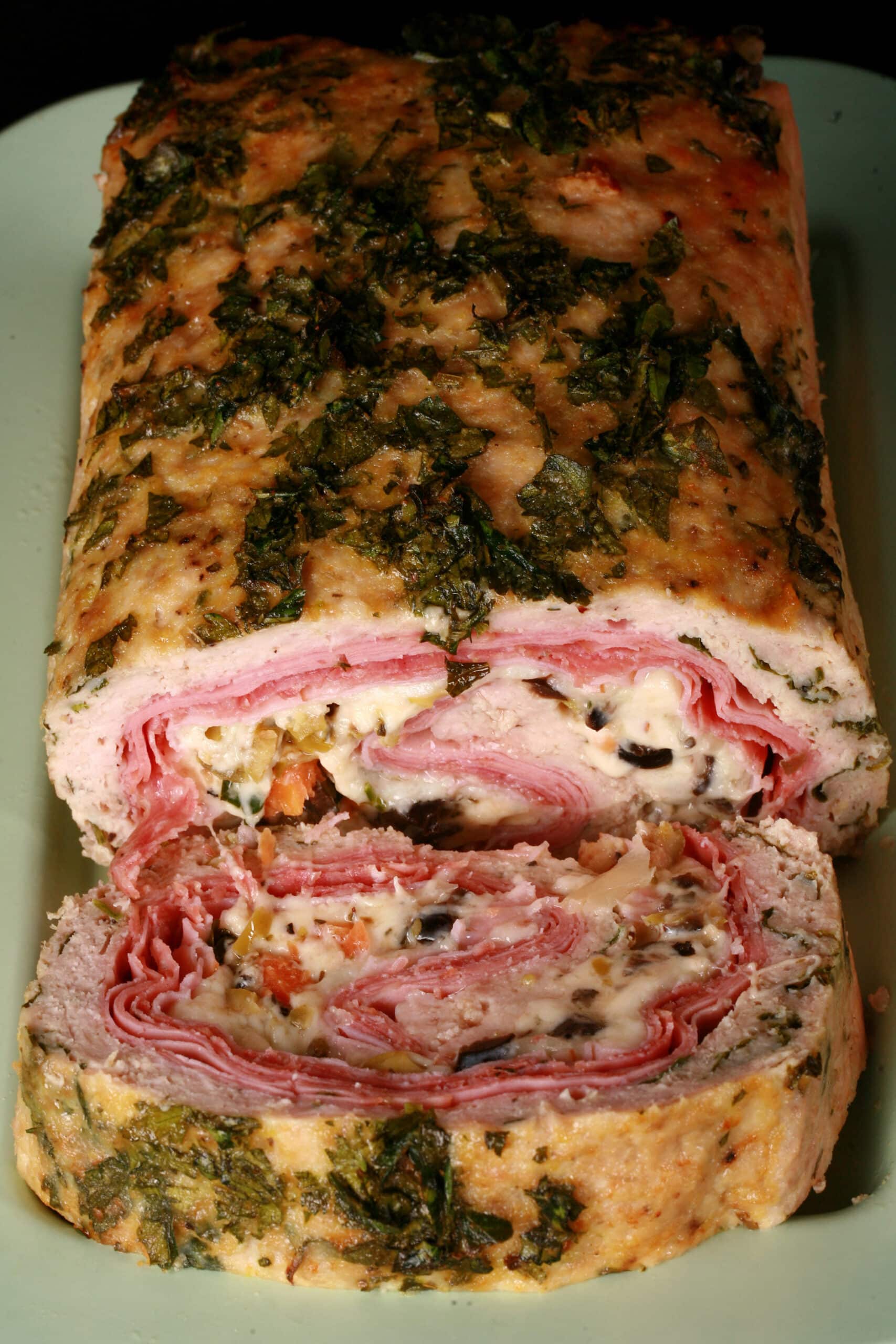 A close up view of a muffaletta stuffed meatloaf.