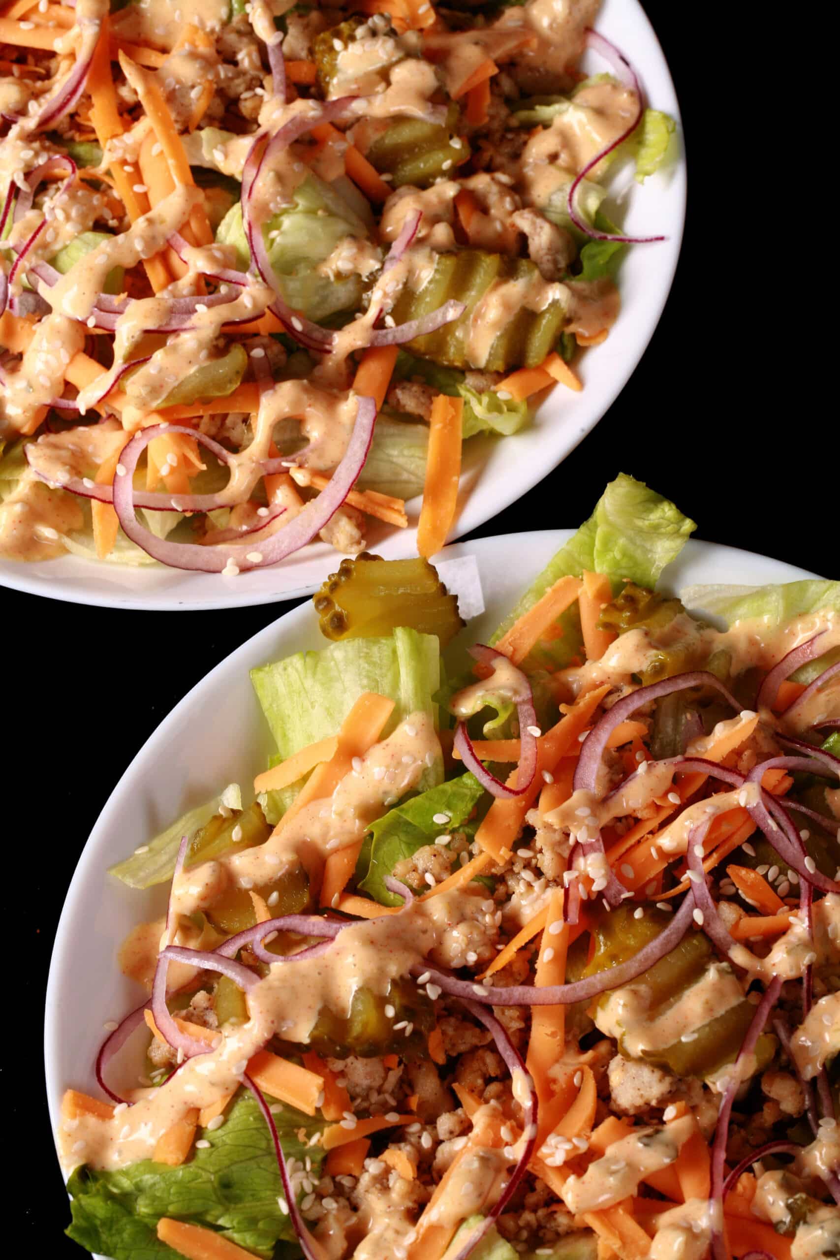 2 bowls of low carb big mac salad, with iceberg lettuce, ground beef, cheese, pickles, onions, and keto big mac sauce.