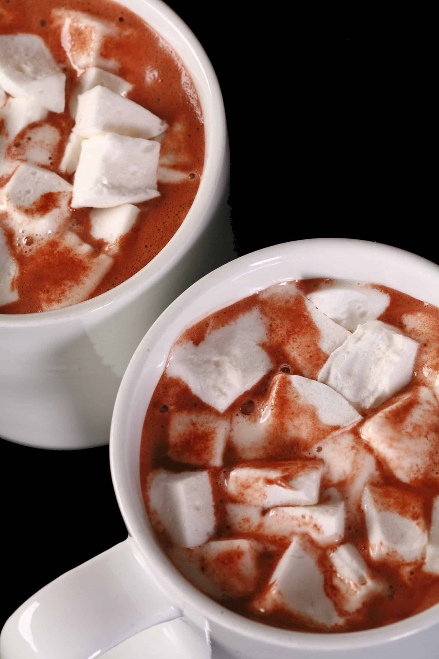 2 mugs of sugar free hot chocolate topped with sugar free marshmallows.