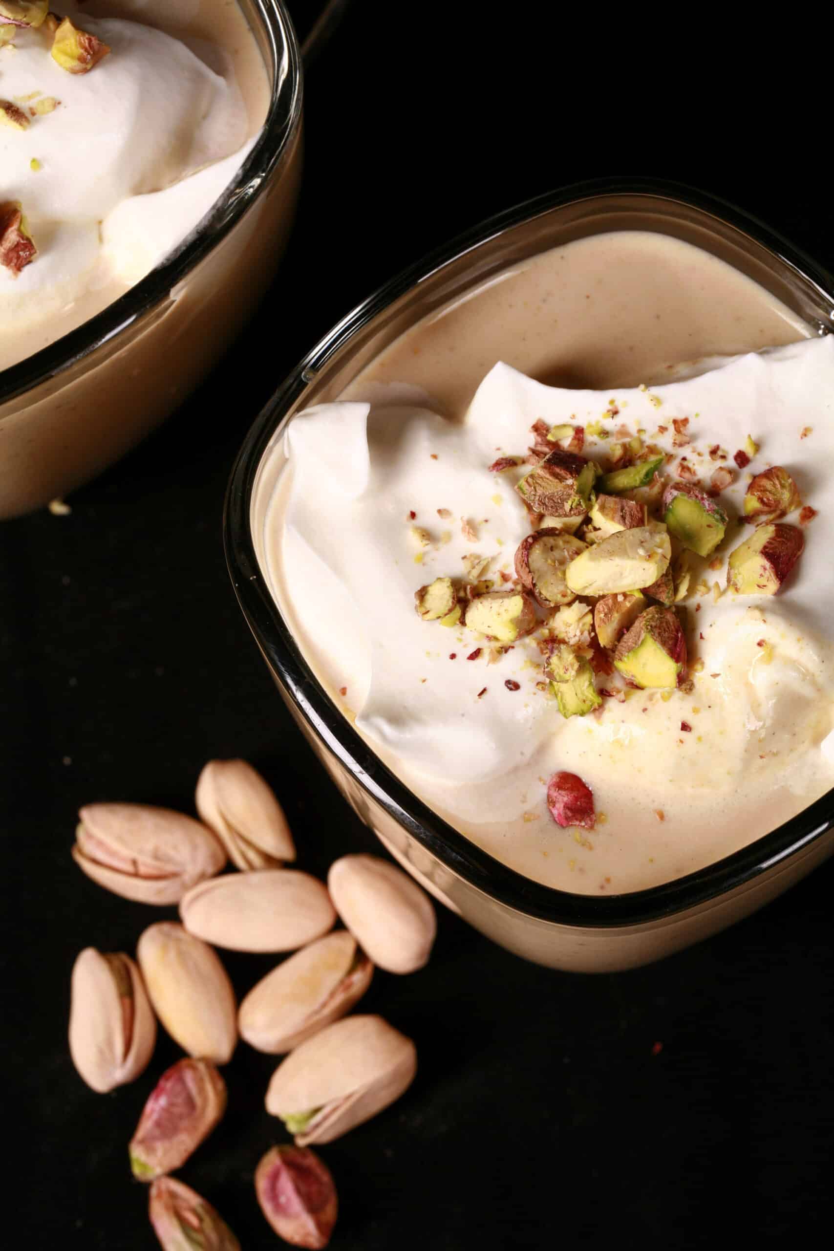 2 mugs of sugar free pistachio white hot chocolate topped with whipped cream and chopped pistachios.