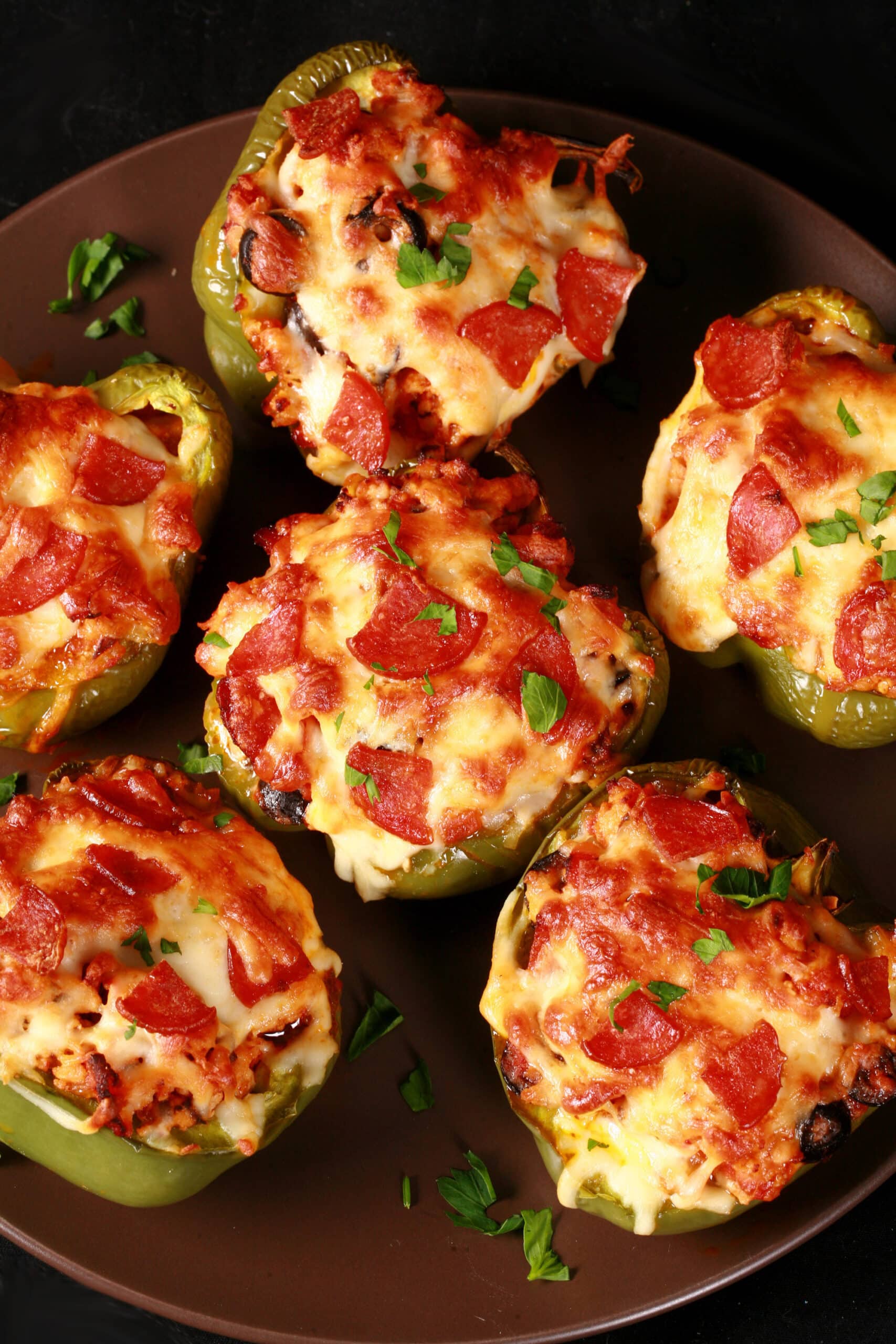 Several low carb pizza stuffed peppers on a plate.