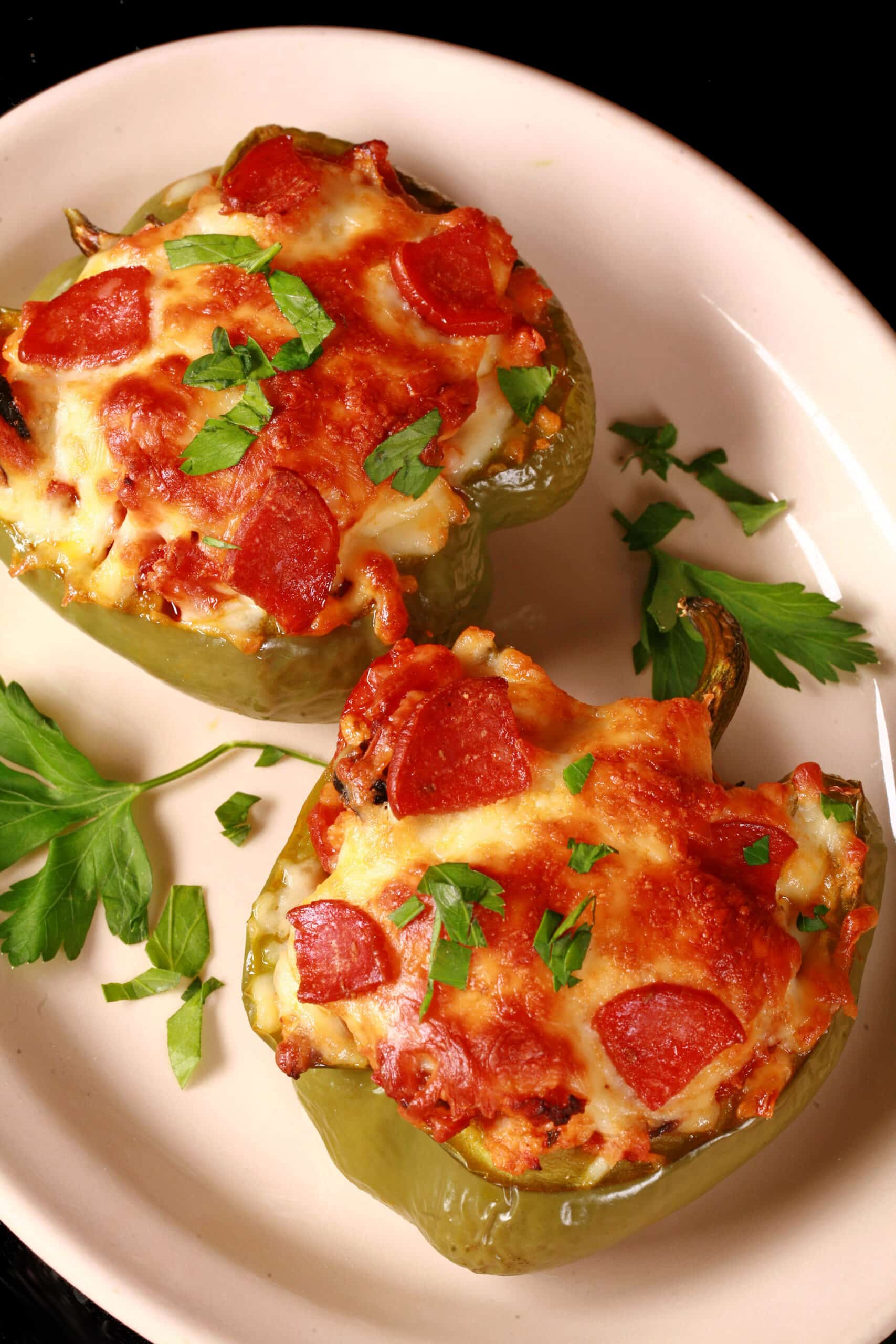 2 keto pizza stuffed peppers on a plate.