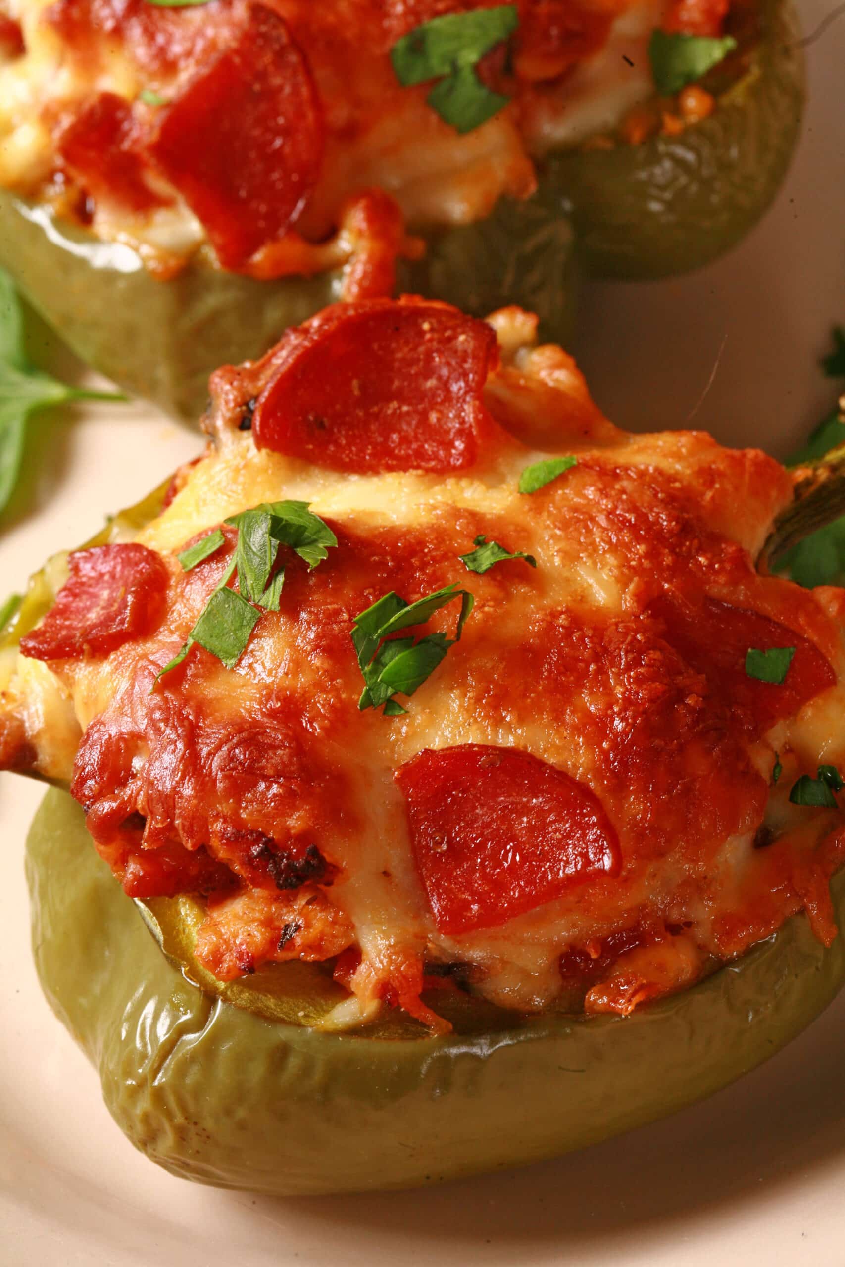 2 low carb pizza stuffed peppers on a plate.