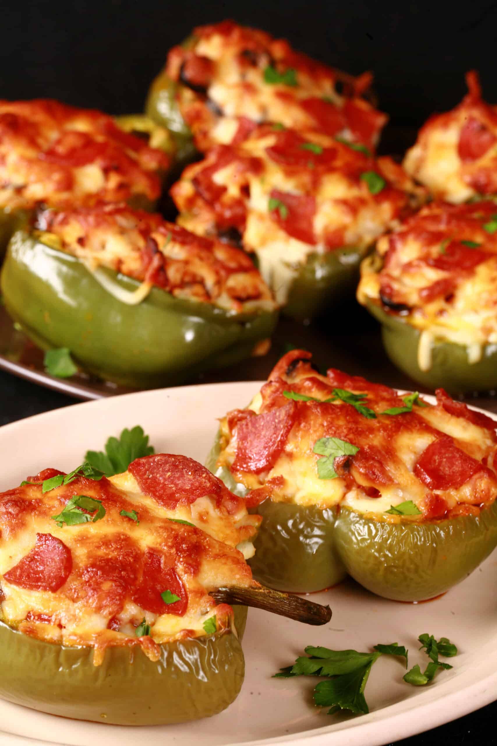 Several keto pizza stuffed peppers on a plate.