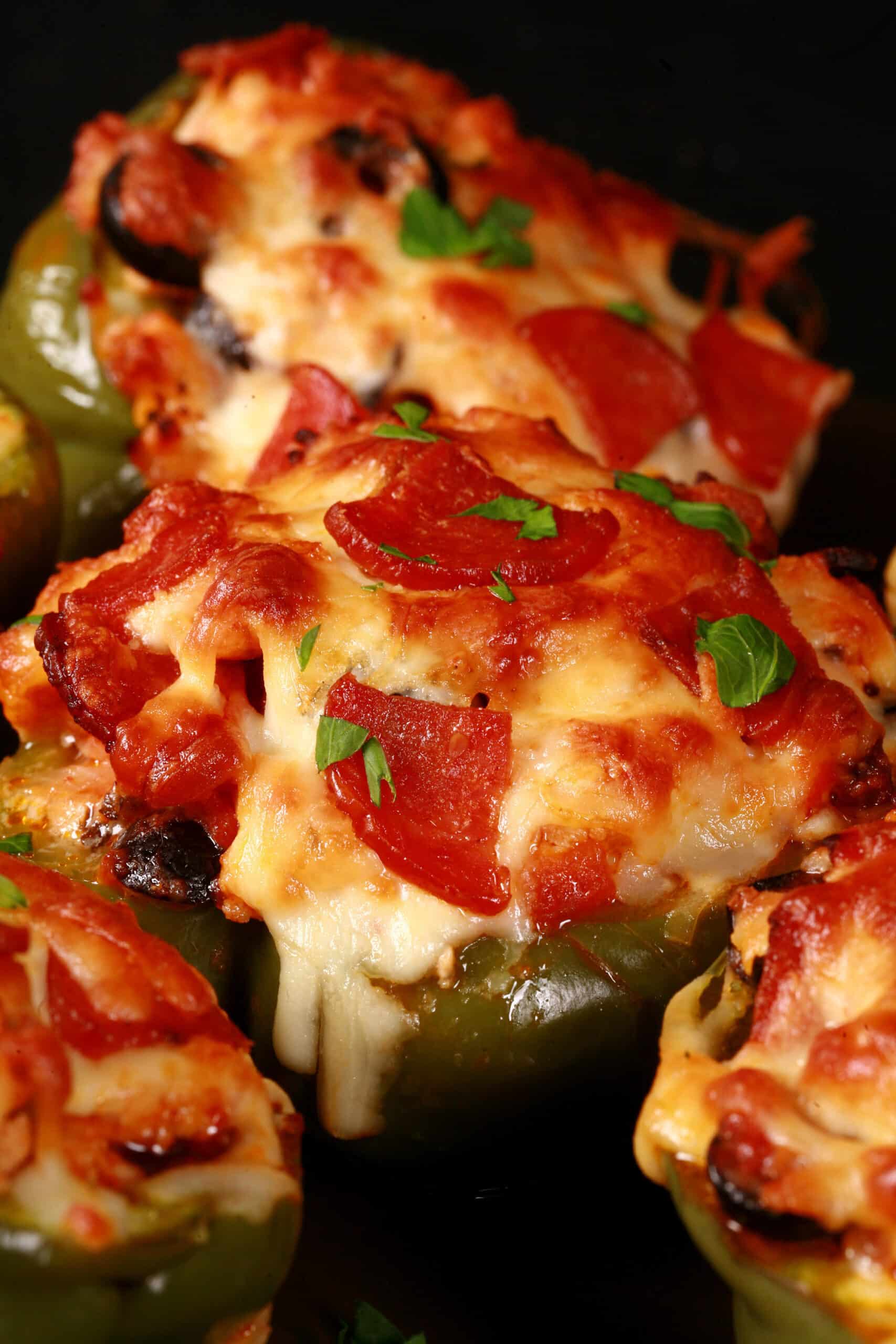 Several low carb pizza stuffed peppers on a plate.