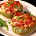 2 low carb pizza stuffed peppers on a plate.