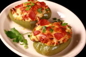 2 low carb pizza stuffed peppers on a plate.