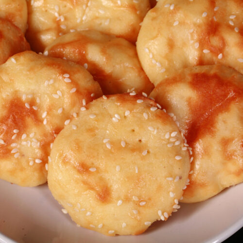 A plate of low carb mini pita rounds with sesame seeds.