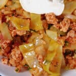 A bowl of keto cabbage roll in a bowl topped with sour cream.