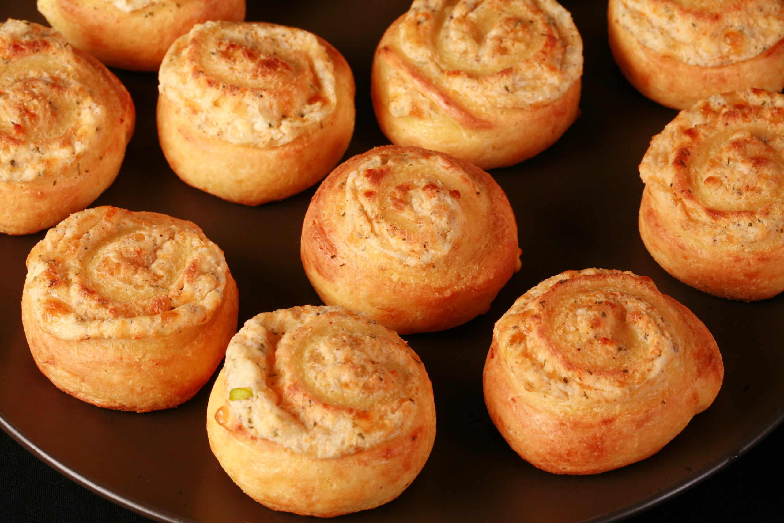 A plate of fathead pastry keto onion and cheese pinwheels.